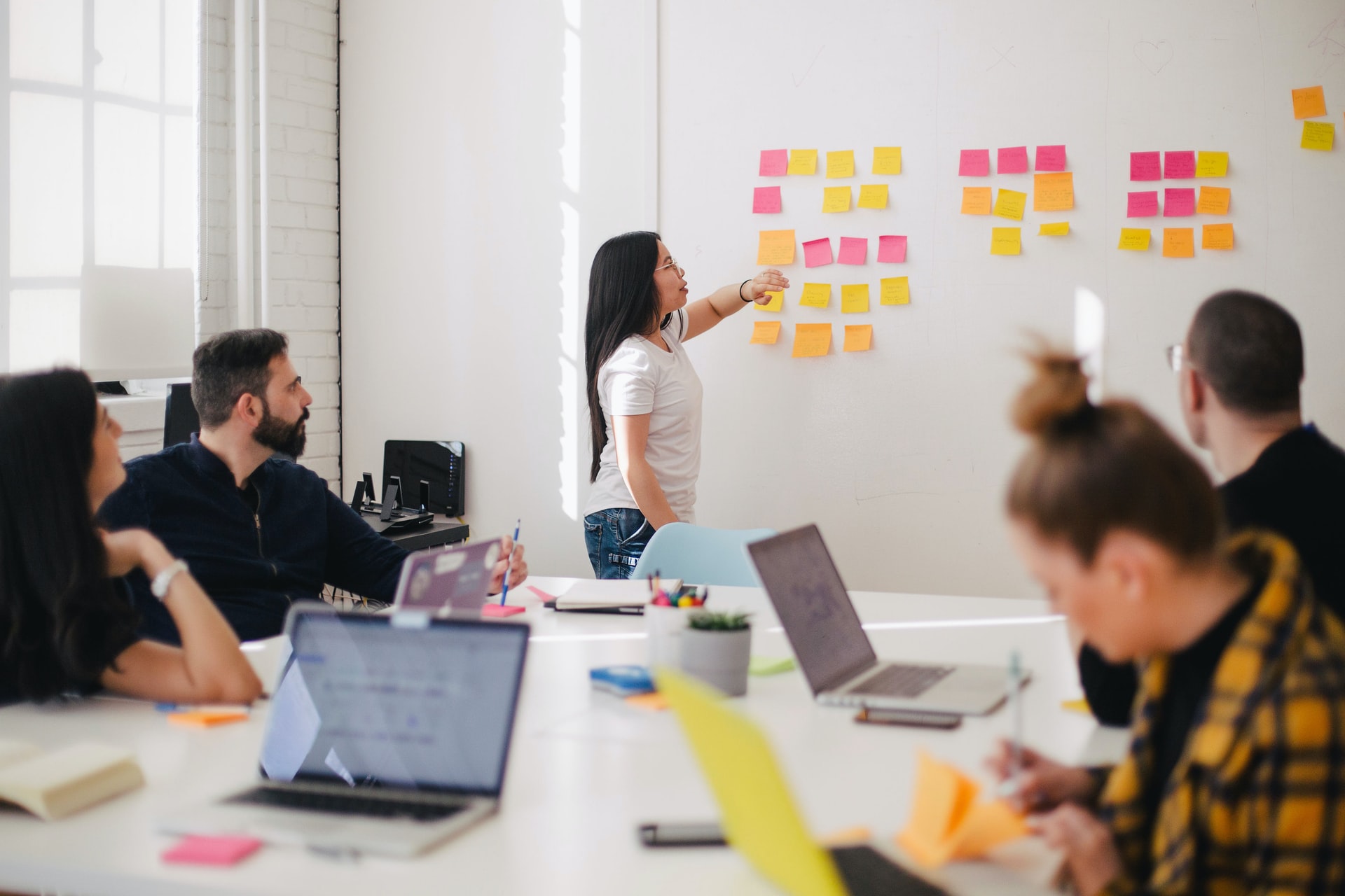 Team of Employees Brainstorming Ideas With Sticky Notes on the Wall